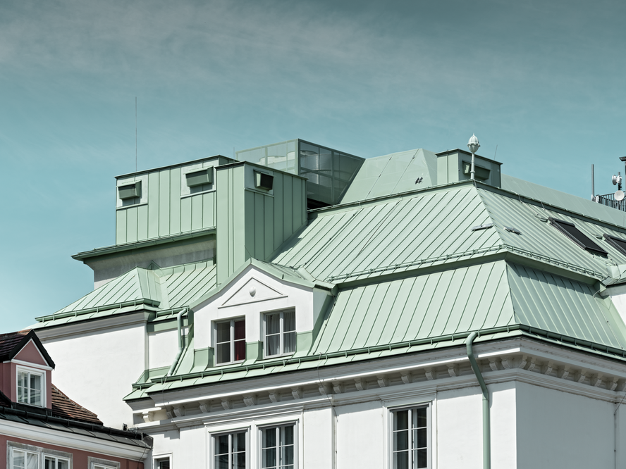 Nahaufnahme der denkmalgeschützten Hauptfeuerwache am Hof in Wien bei blauem Himmel, eingedeckt mit PREFALZ in der Sonderfarbe Opalgrün.
