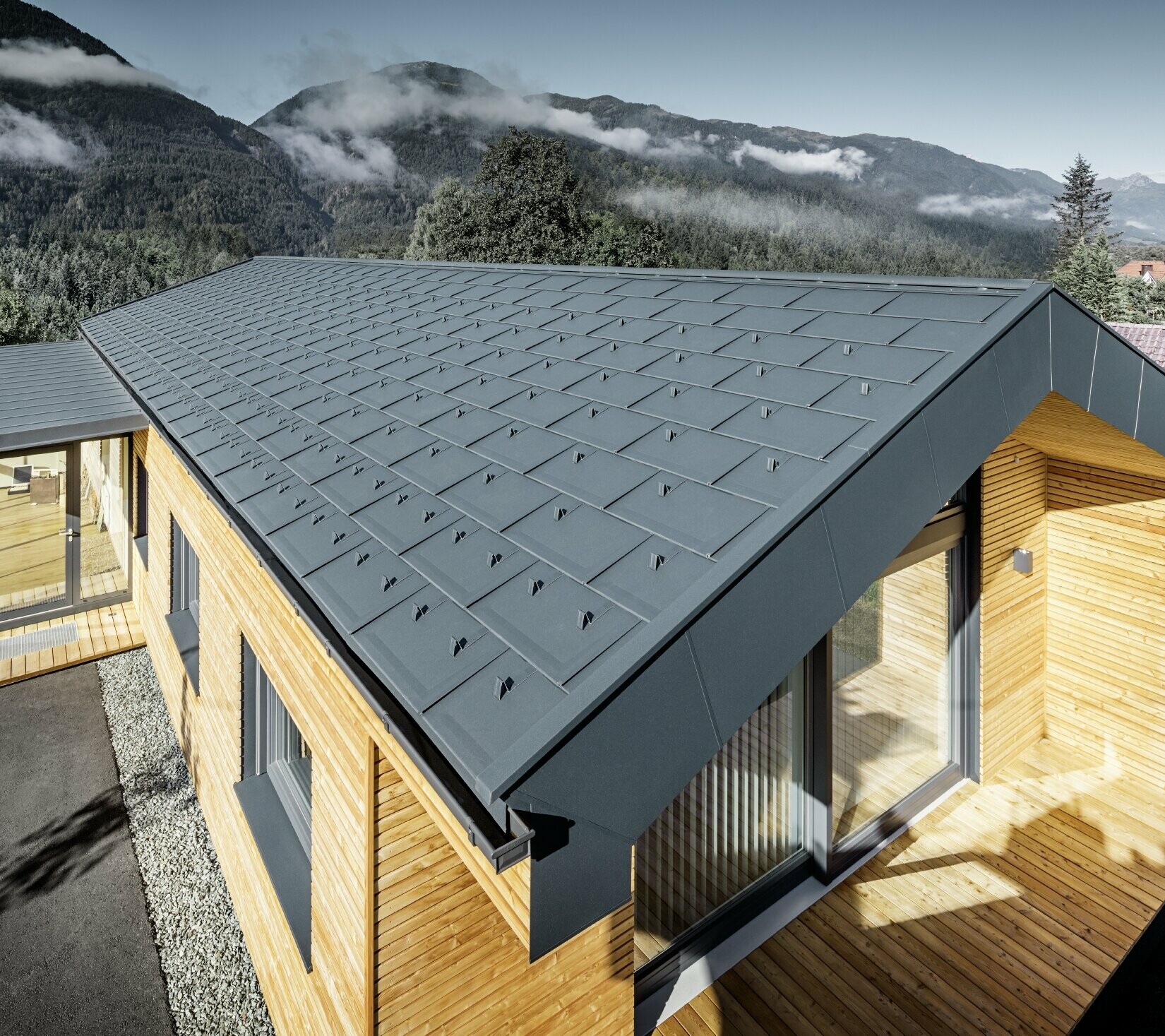 Nouvel immeuble de bureaux de Holzbau Faltheiner avec une façade en bois de mélèze, des fenêtres généreuses et une toiture PREFA en anthracite.