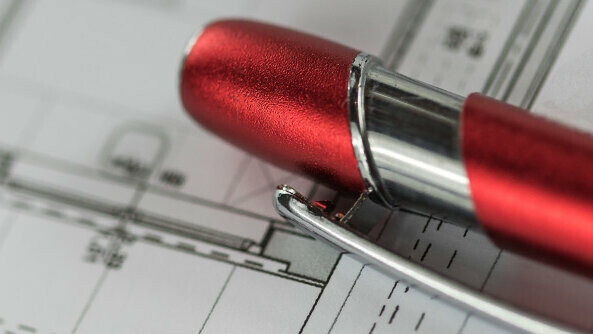 Un stylo PREFA rouge est posé sur un plan