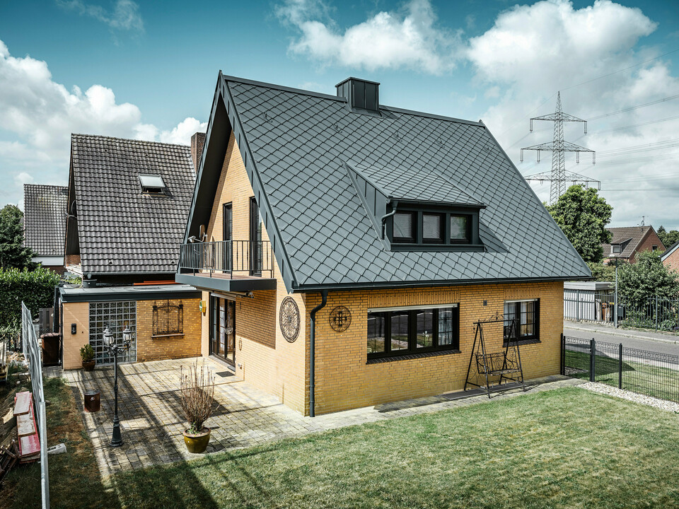 Losange de toiture 29x29 PREFA, joint debout PREFALZ, gouttière suspendue et tuyau de descente de couleur P.10 anthracite ornent une maison individuelle à Tönisvorst.