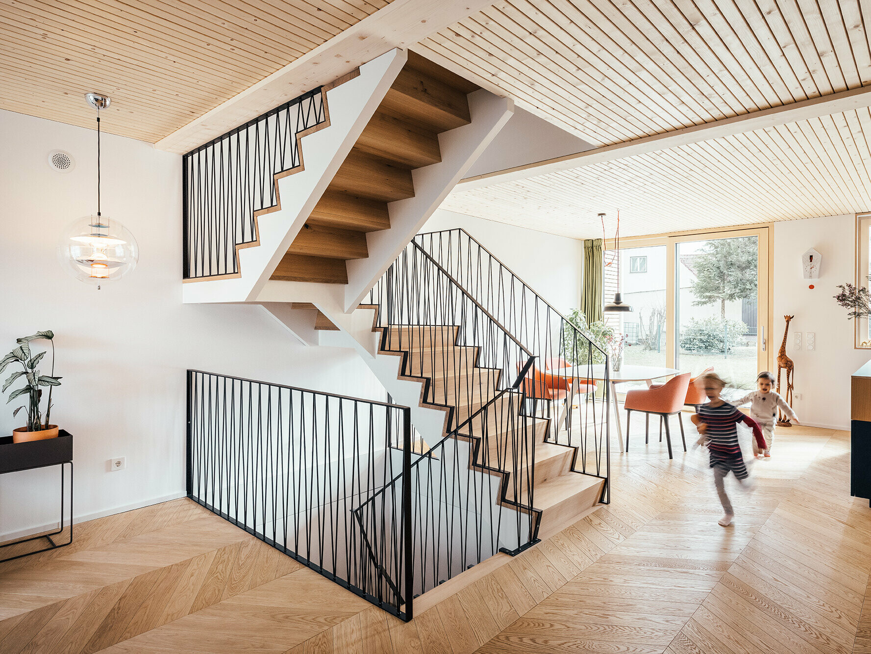 Interieur Haus West, farbliches Zusammenspiel: weiße Wände, Fischgrätenparkett in Eiche, Sichtholzdecke aus Fichte.