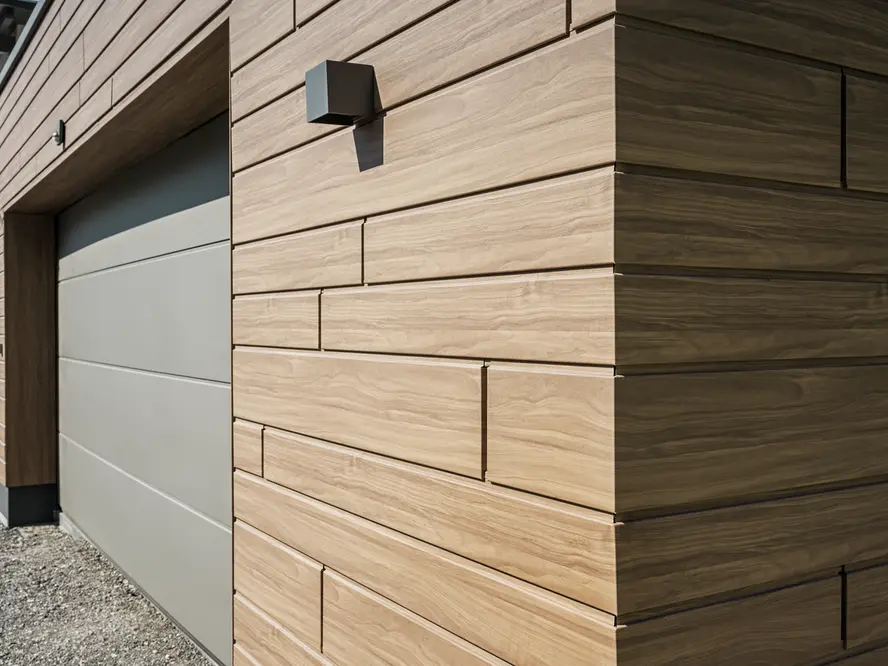 Photo de détails d'un garage, qui a été recouvert de Siding dans une teinte bois. La teinte choisie est le noyer foncé.