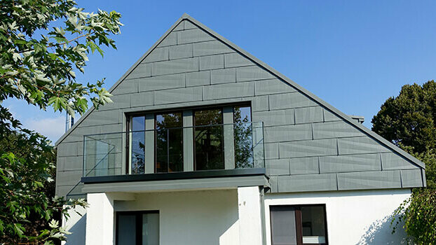 Fassadensanierung mit dem Fassadenpaneel FX.12 von PREFA Giebelverkleidung einer frisch sanierten Fassade mit dem PREFA Fassadenpaneel FX.12 in Hellgrau.