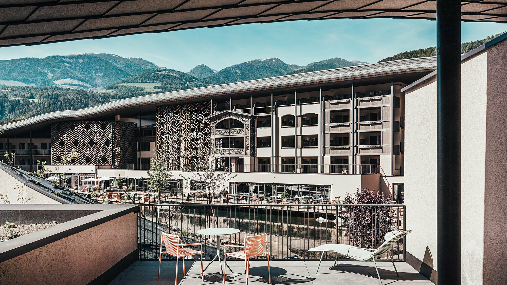 Ein Blick von der Terrasse auf das Falkensteinerhotel. Hügelige Berglandschaft ist im Hintergrund zu sehen.