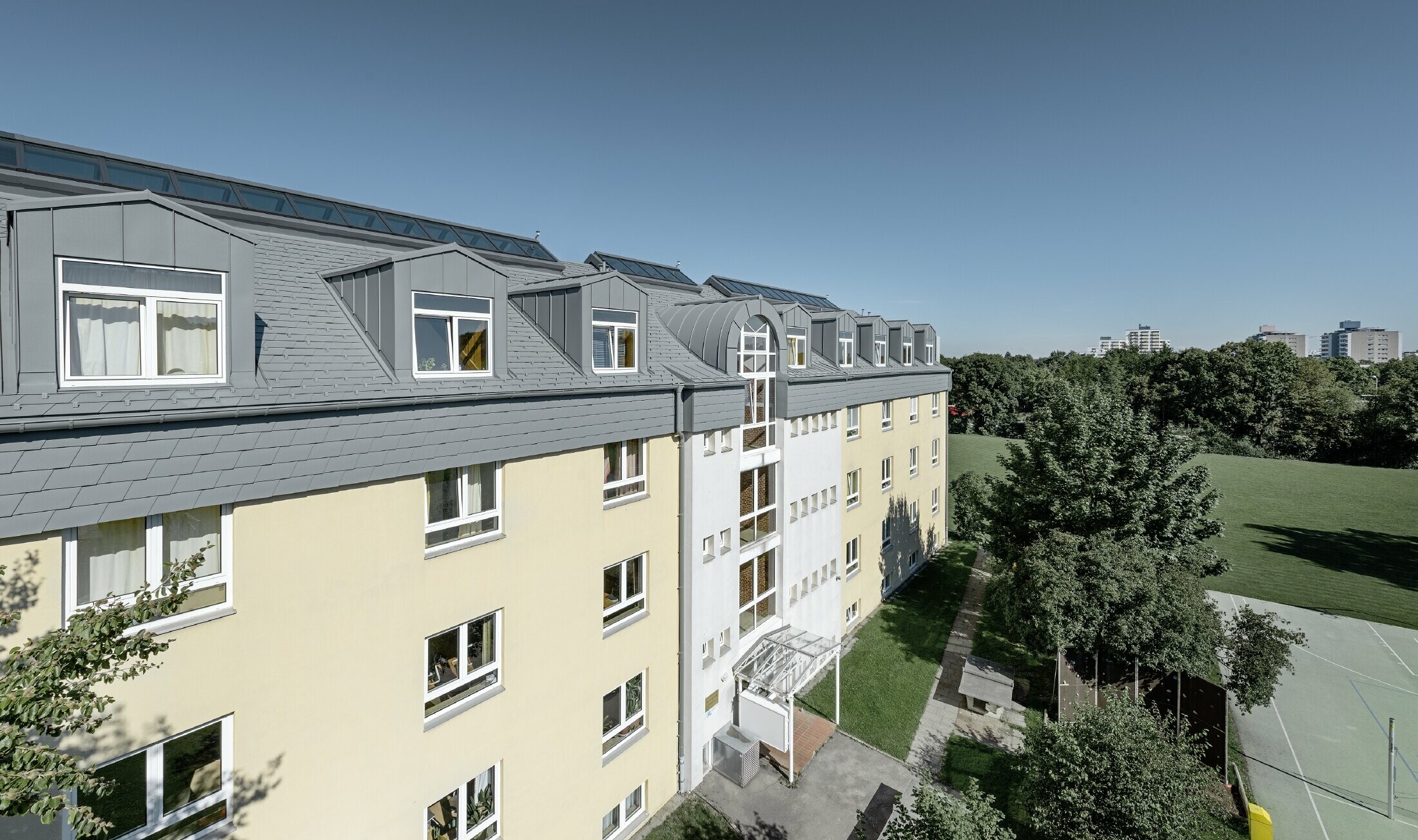 Dachgeschoss des Albertinum in München mit der PREFA Dachschindel und Stehfalz in hellgrau