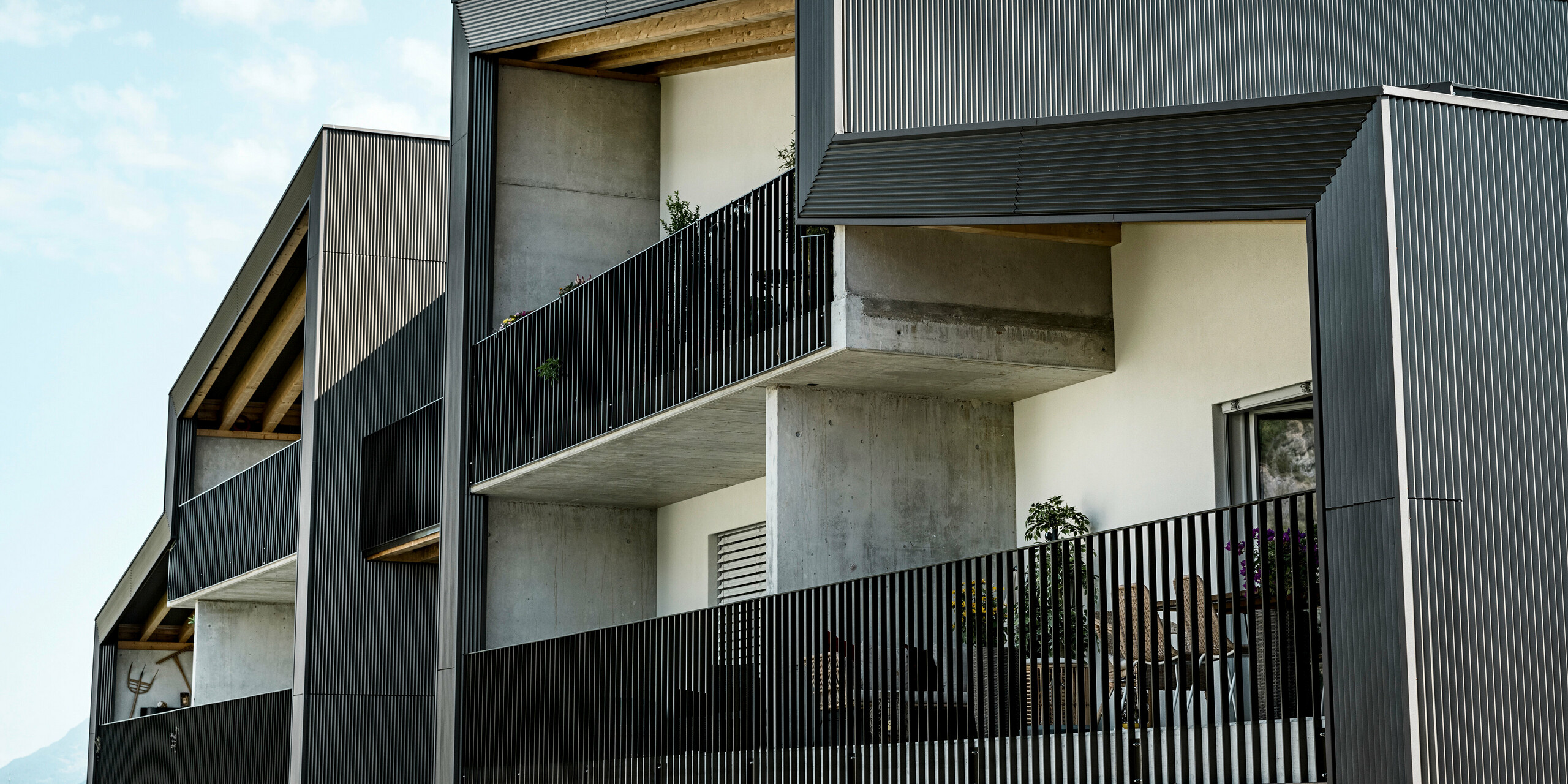 La façade du complexe résidentiel Les Dailles a été largement recouverte de l'impressionnant profil triangle PREFA en bronze. Le toit du bâtiment a été recouvert de PREFALZ en bronze.