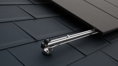 Gros plan sur une toiture PREFA équipée de modules photovoltaïques fixés à l'aide des accessoires PREVARIO pour panneaux solaires.