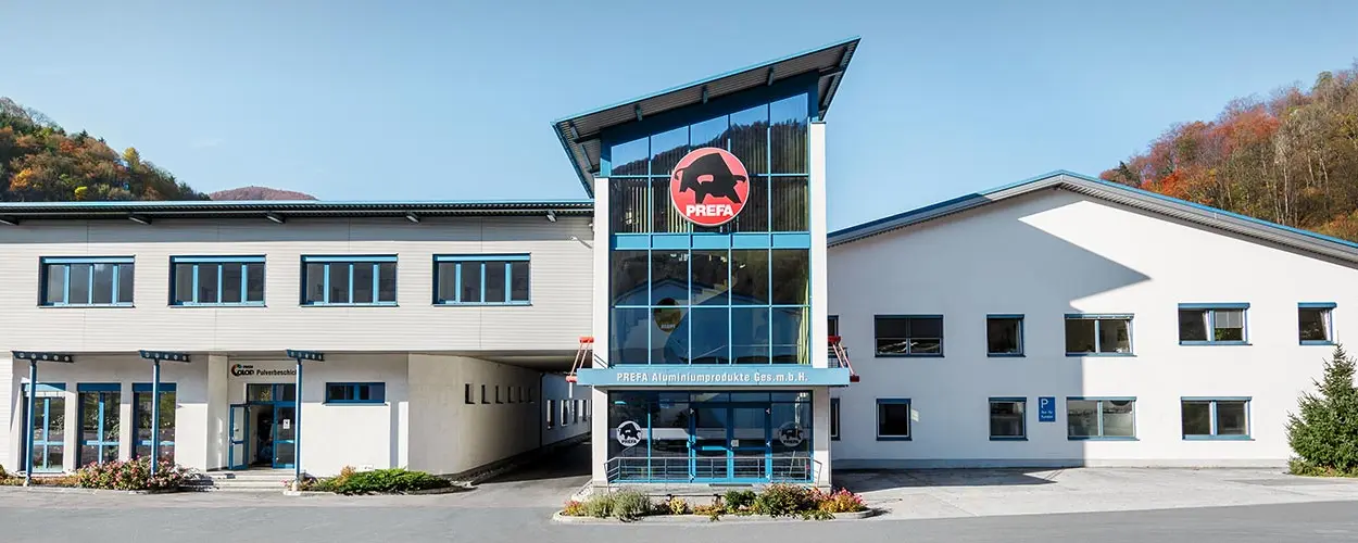 PREFA Firmengebäude mit weißer Fassade und blauen Fenstern