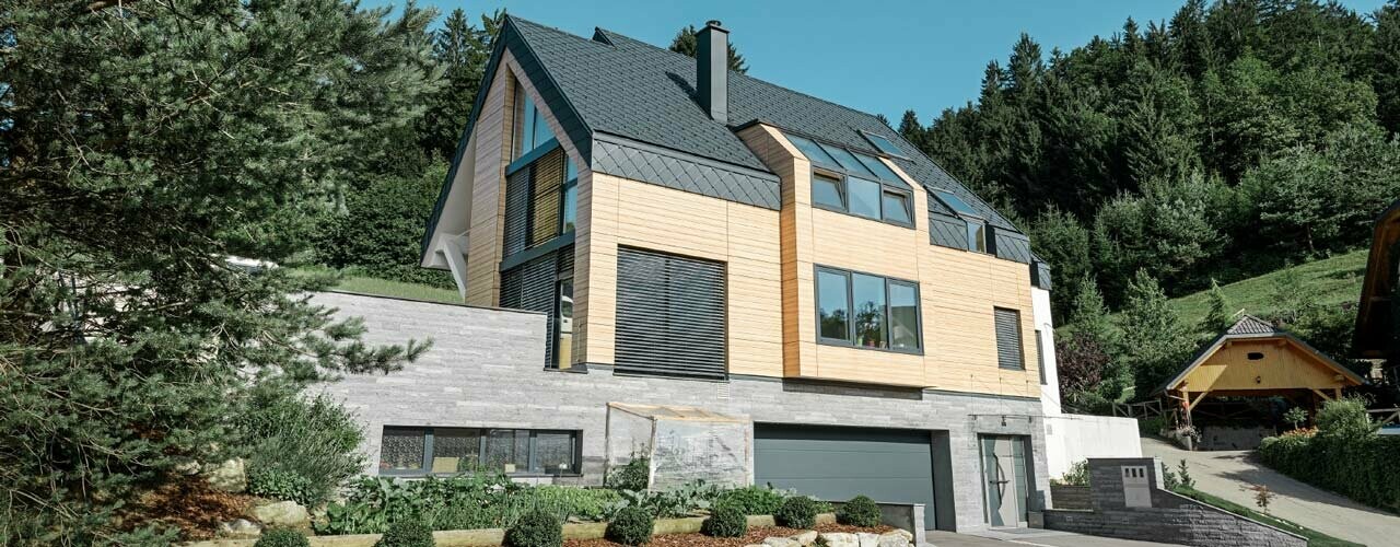 Nouvelle construction avec façade en bois clair et toiture en losanges de toiture PREFA couleur P.10 anthracite