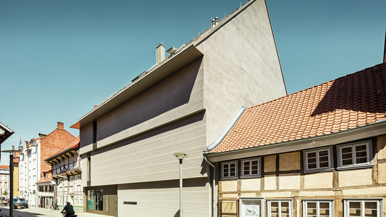 Blick auf das Kunsthaus in Göttingen, welches von urigen Häusern umgeben ist.