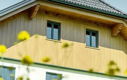 Revêtement de pignon avec panneaux en aluminium de PREFA imitation (chêne naturel) ; les Sidings sont posés à la verticale avec revêtement de la sous-face de toiture