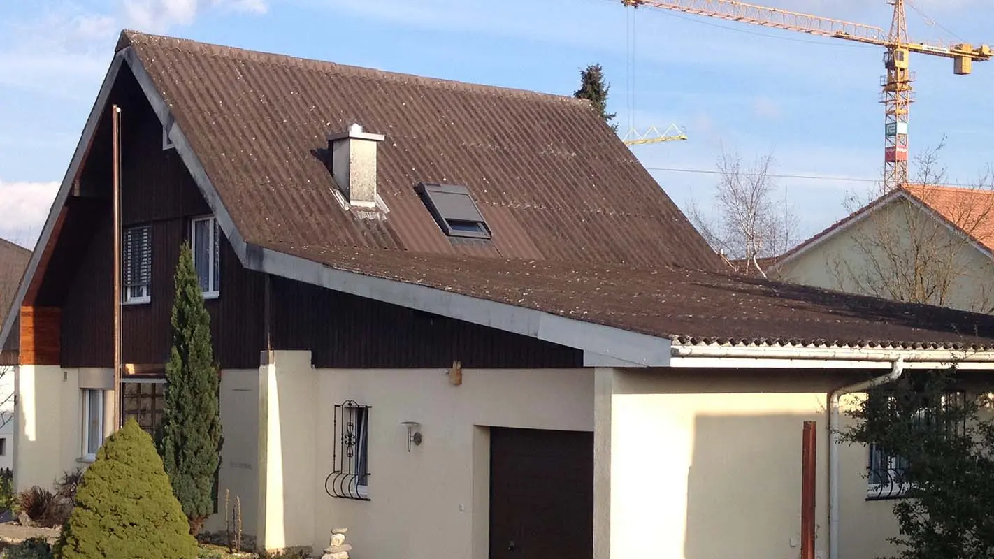 Maison avant la rénovation de toiture à l’aide de tuiles PREFA, toit à deux pans et garage