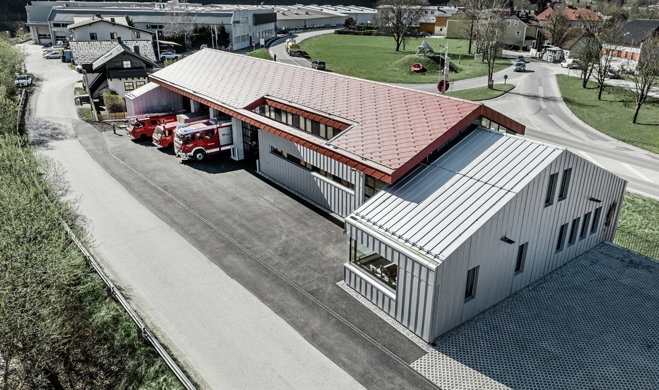 Aufnahme der Betriebsfeuerwehr in Marktl/Lilienfeld in der Vogelperspektive. Der linke Gebäudeteil wurde komplett am Dach und der Fassade mit der raute 44 in Oxydrot verkleidet. Der rechte Teil bekommt eine Aluminiumhülle mit Prefalz in Silbermetallic.