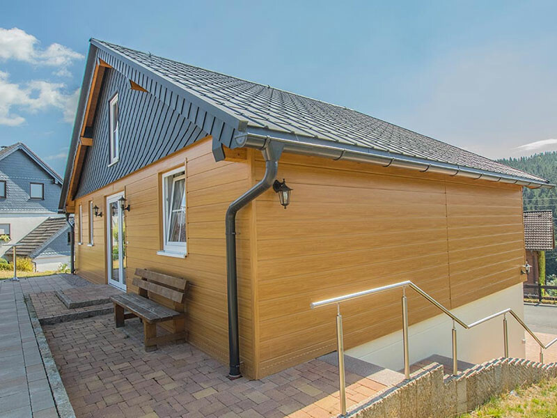 Wohnhaus mit einer vorgehängten hinterlüfteten Fassade von PREFA mit Sidings in heller Holzoptik und Wandrauten.