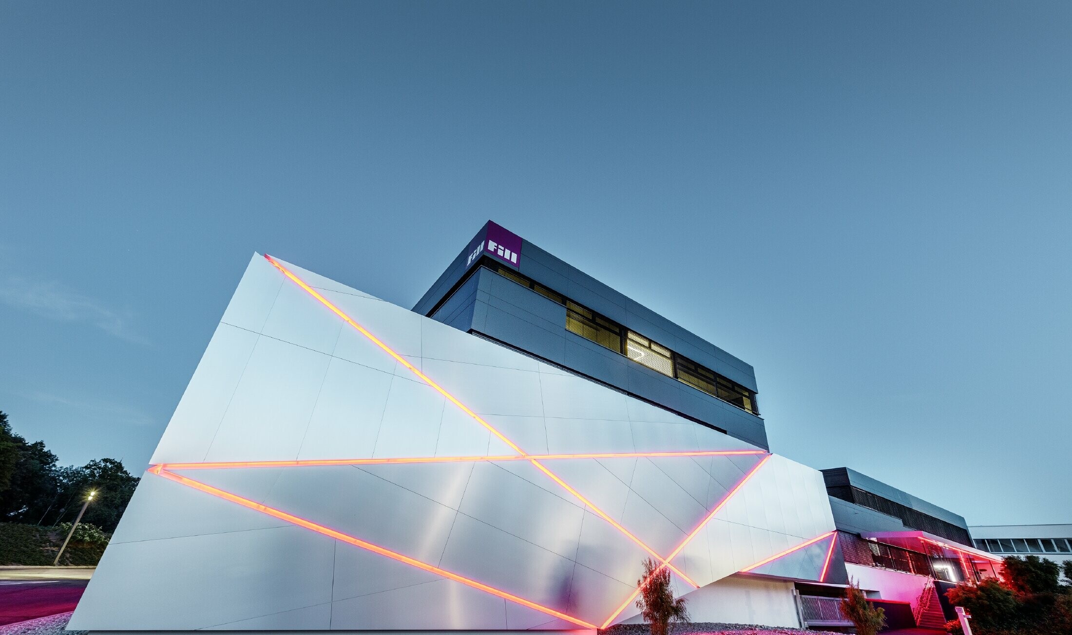 Bâtiment d’entreprise de la société Fill — Façade futuriste aux joints rétroéclairés réalisée avec des panneaux composites PREFA en aluminium brossé