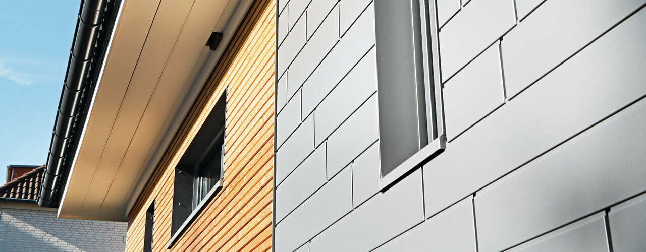 Combinaison de Sidings PREFA en aluminium couleur gris aluminium avec une façade en bois. Pose horizontale, joints décalés.