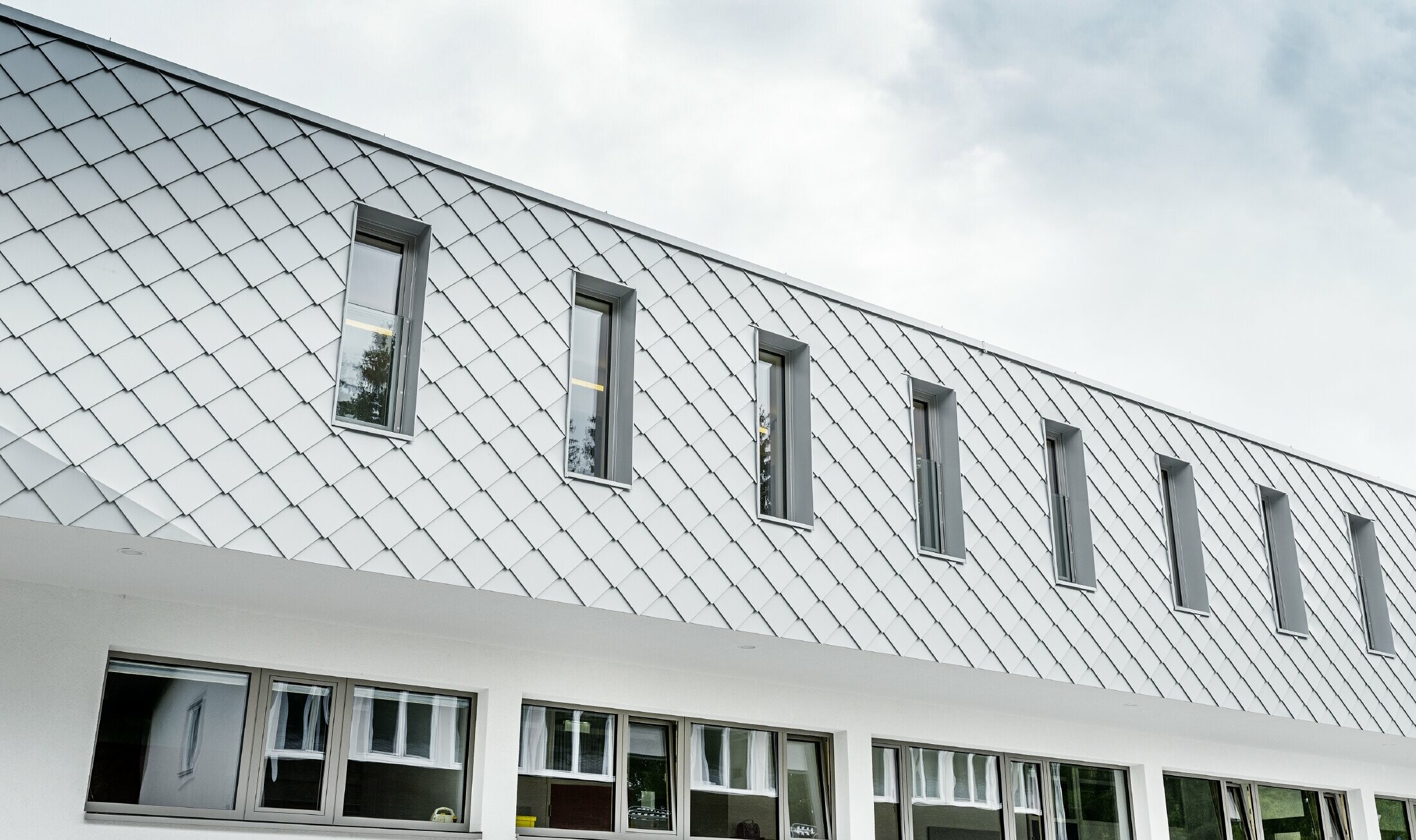 Nouvelle crèche à Kaprun avec façade moderne en aluminium et losange de façade PREFA en blanc Prefa