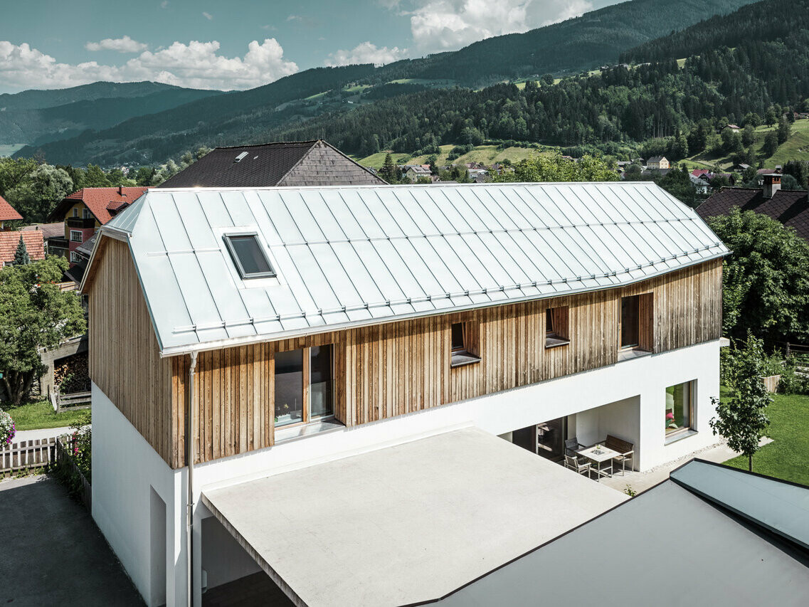 Seitliche Ansicht des modernen Einfamilienhauses im schönen Ort Pruggern. Das Dach wurde mit PREFALZ in der Farbe Naturblank eingedeckt.