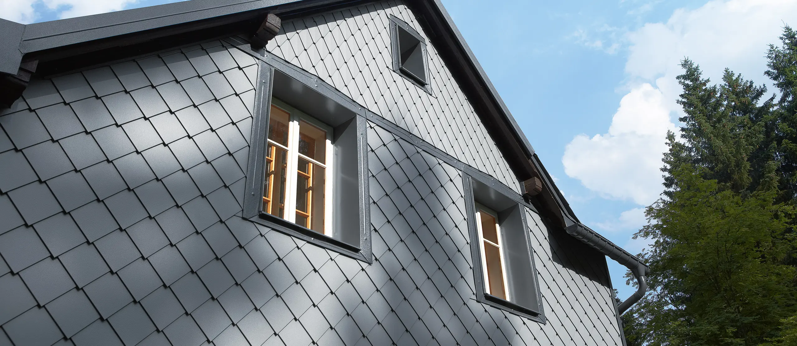 Wetterseite verkleidet mit der Wandraute 20 × 20 und der kleinen Raute an der Fassade von PREFA