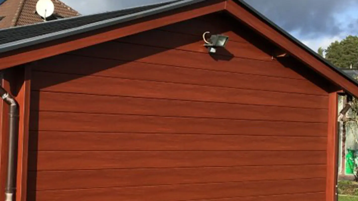 Saniertes Gartenhaus, mit einer neuen Wandverkleidung in Holzoptik, davor war es mit Holz verkleidet, jetzt mit den PREFA Sidings in einem dunklen Holzton
