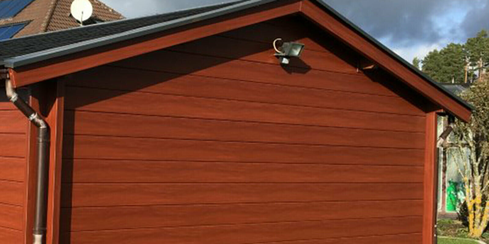 Abri de jardin rénové, avec un nouveau revêtement mural imitation bois, auparavant recouvert de bois, maintenant avec Sidings PREFA couleur bois