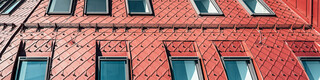 Detailansicht der auffälligen Dachlandschaft aus oxydroten Aluminiumrauten.