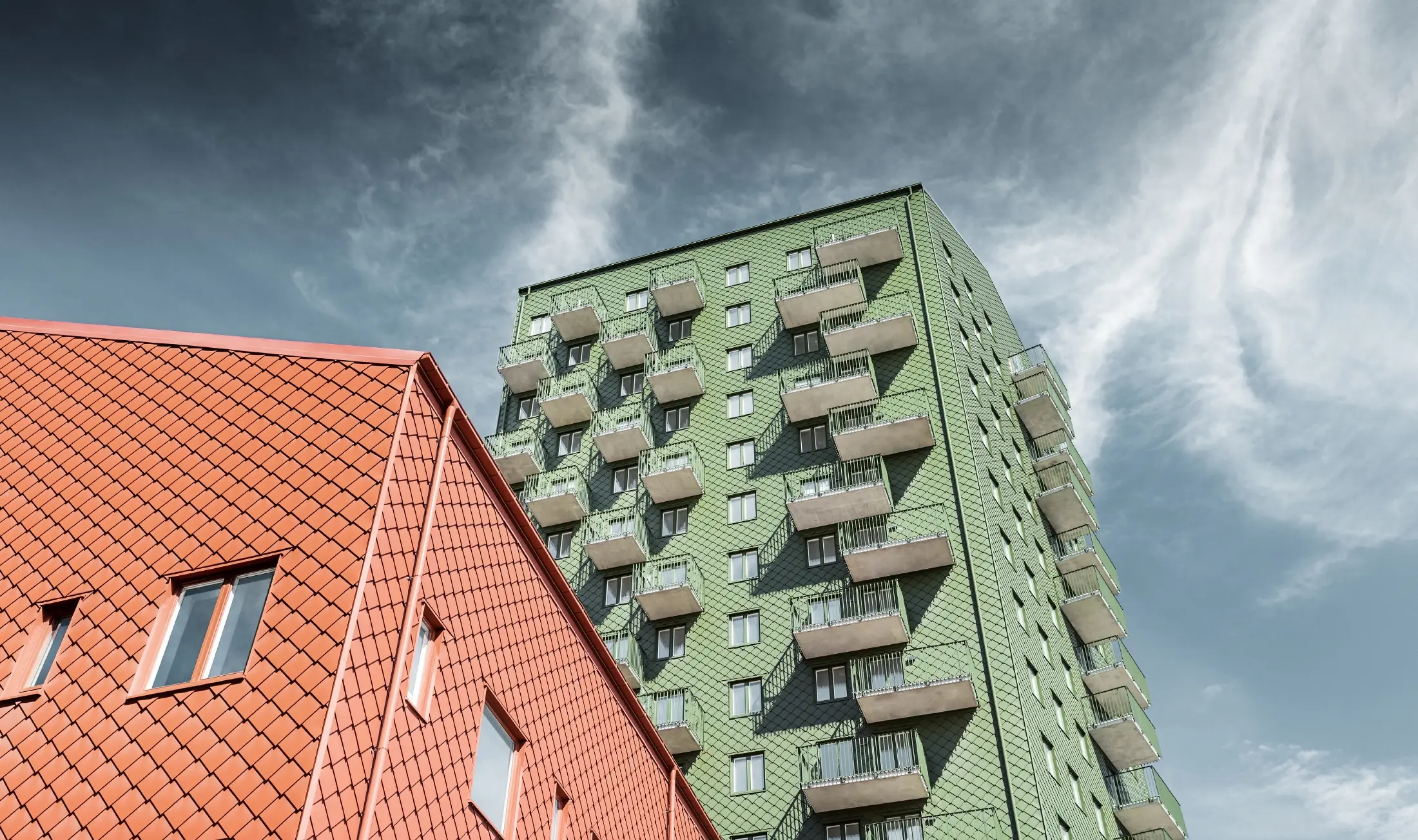 Conception de façade avec losange de façade PREFA 29 x 29 en vert olive et rouge tuile