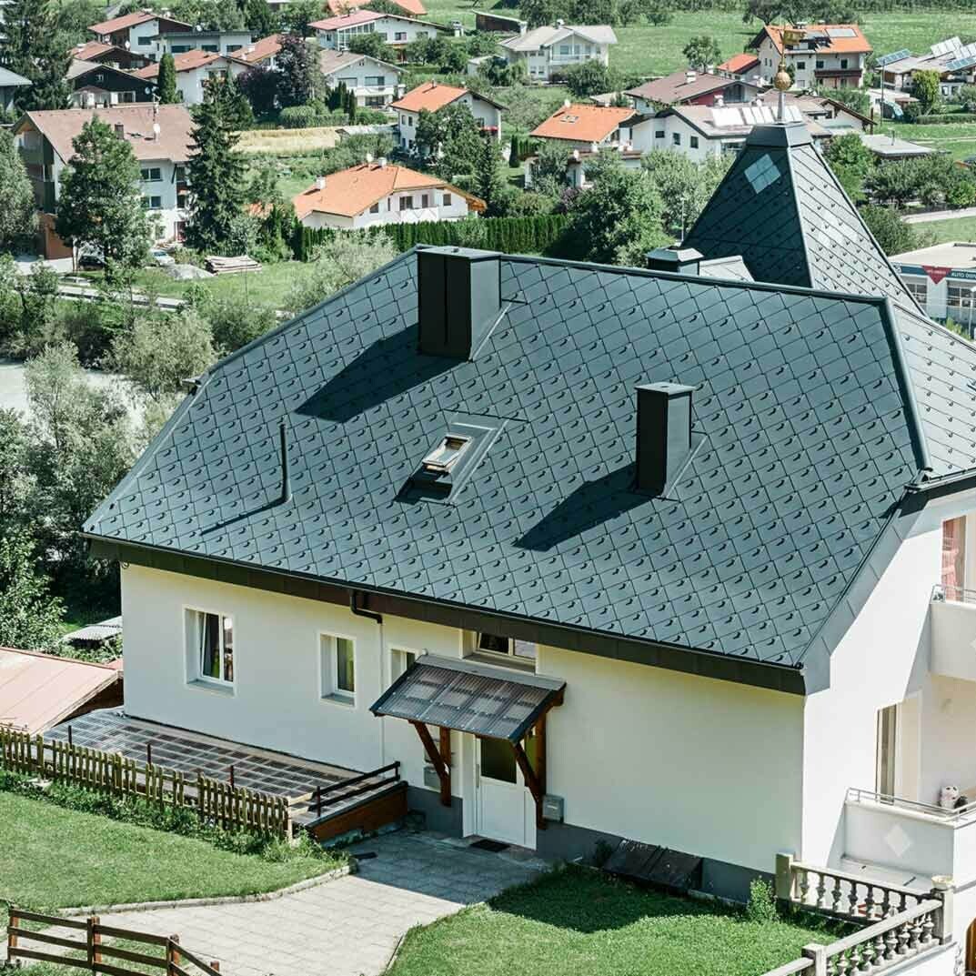 Küppelwalmdach mit einem Turm, eingedeckt mit der Aluminium Dachraute 44 × 44 in Anthrazit.