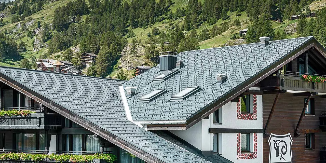 Hôtel Alpenhof à Zermatt avec balcons, façade en bois foncé et le Cervin en toile de fond — Toiture en aluminium PREFA de couleur anthracite