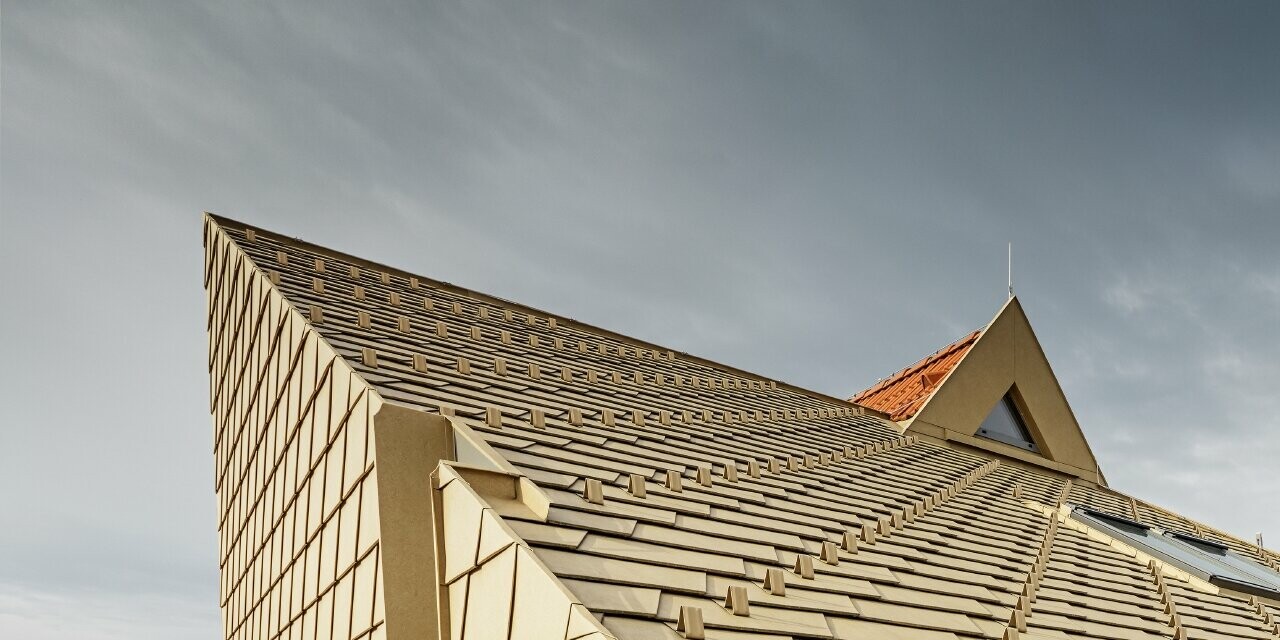 Extension de maison sans avancée de toit avec gouttière encaissée ; le choix s’est porté sur les bardeaux PREFA couleur brun sable