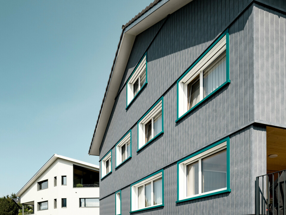 Sidings PREFA en gris pierre P.10 et blanc Prefa P.10 sur les façades de deux immeubles d'habitation voisins à Weissbad, en Suisse.