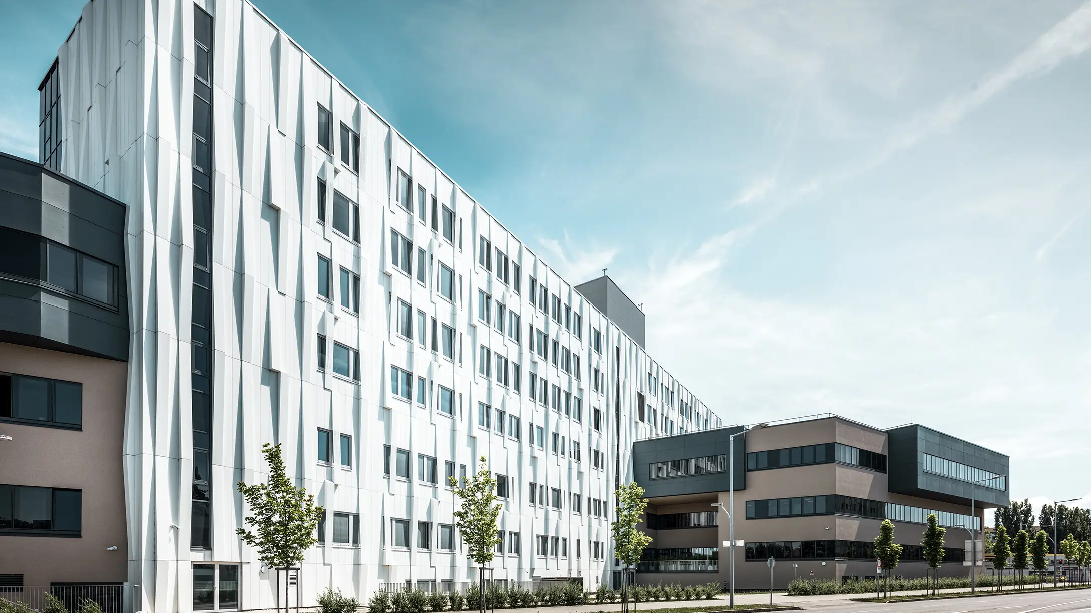 Entrée de la gare routière de Lenti ; la sous-face de la toiture est revêtue de panneaux composites en aluminium PREFABOND de PREFA en blanc pur, tandis que les éléments de façade au niveau des portes d'entrée et des vitrines sont revêtus de P.10 anthracite.