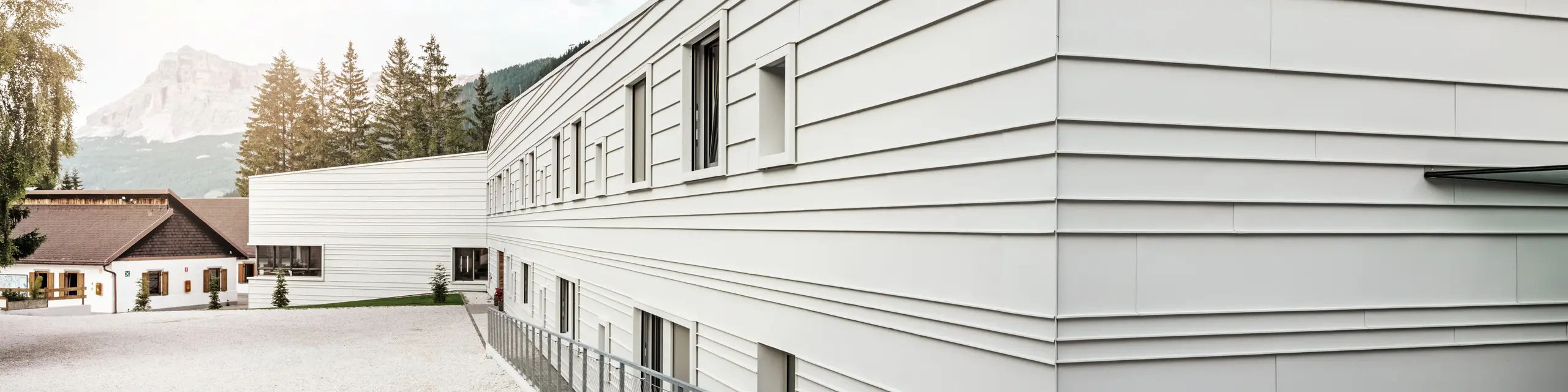 L'architecture moderne de la caserne « Tempesti » fait forte impression avec PREFALZ dans la couleur P.10 blanc Prefa. Les bacs en aluminium posés horizontalement assurent une structure claire. La couleur claire reflète la lumière, ce qui améliore le microclimat dans cet environnement alpin.