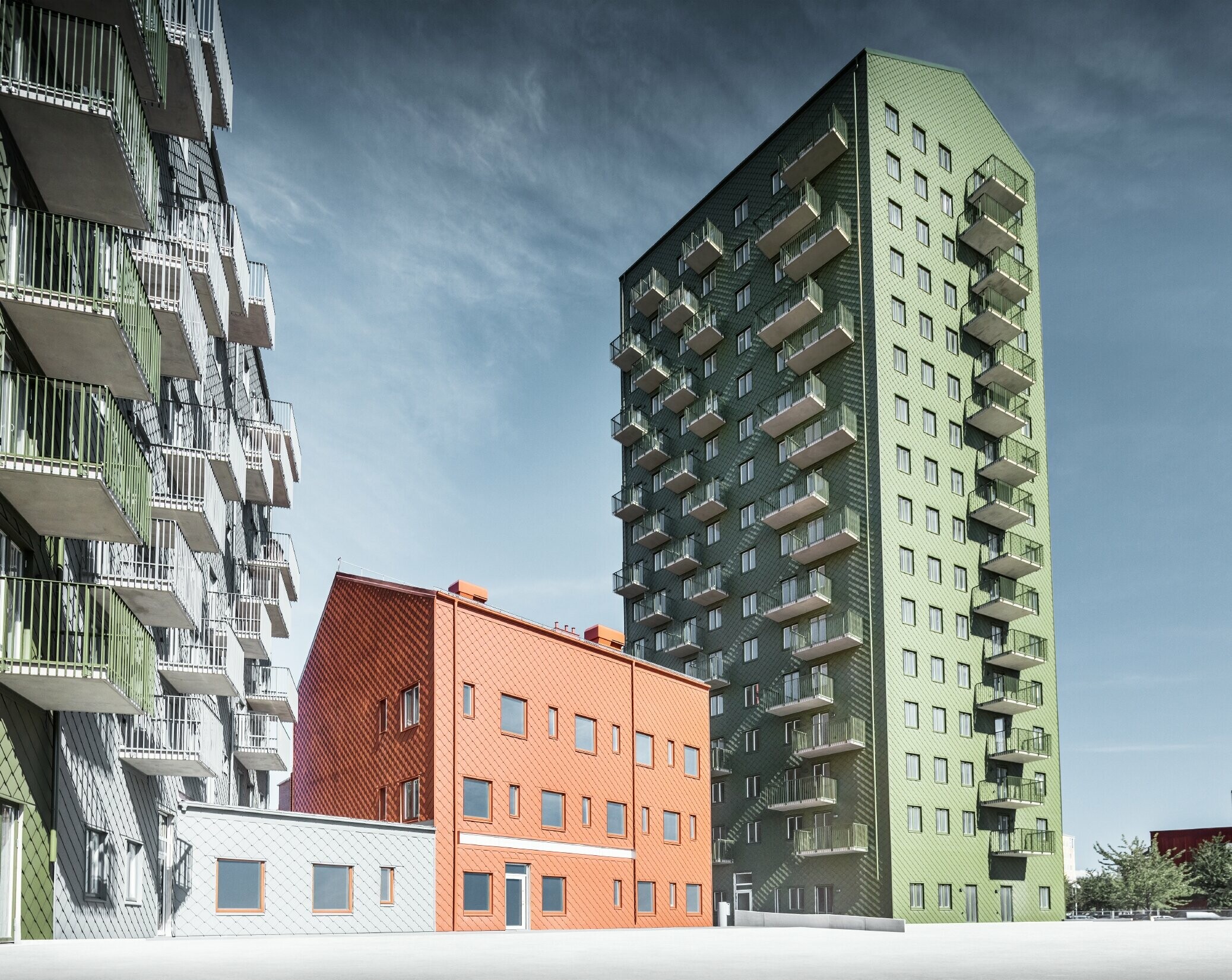 Plusieurs bâtiments d’habitation recouverts de losanges de façade 29 × 29 PREFA dans les teintes vert olive, rouge tuile et gris souris à Göteborg, en Suède.