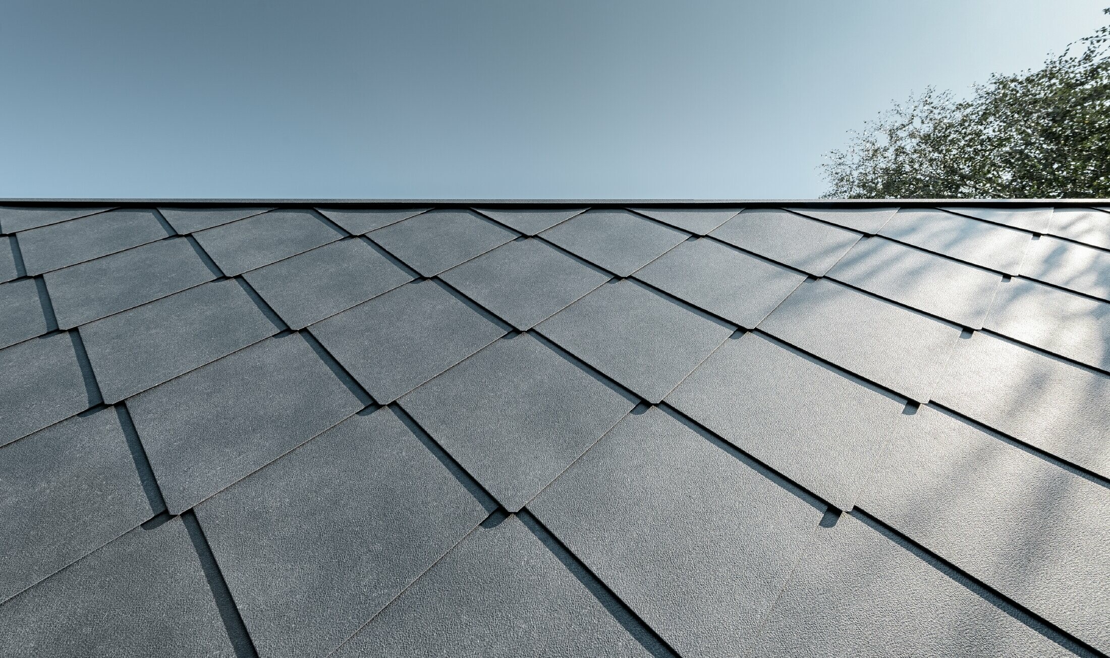 Zubau einer Volksschule eingedeckt mit der Dach- und Wandraute aus Aluminium von PREFA in steingrau