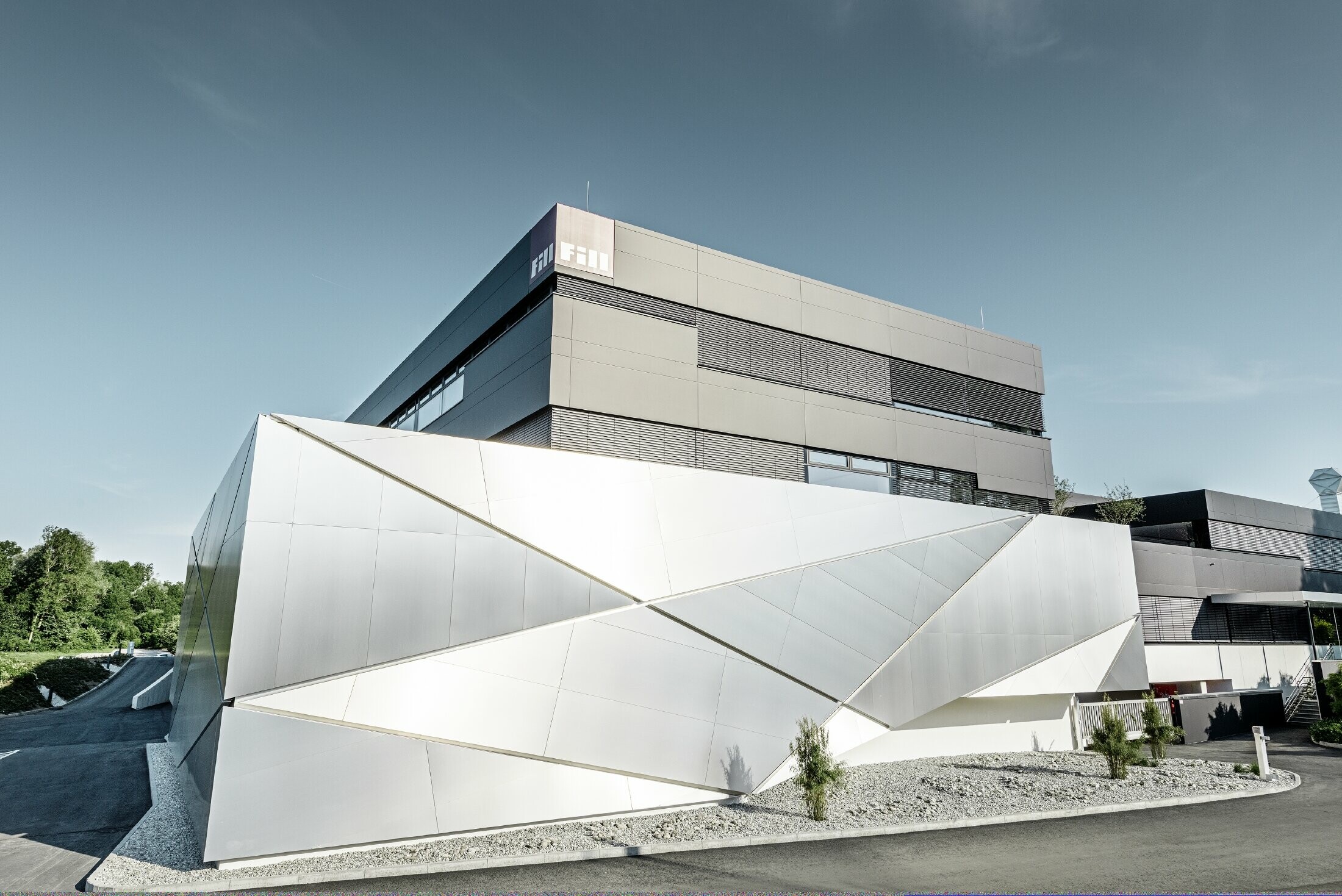 Bâtiment d’entreprise de la société Fill — Façade futuriste aux joints rétroéclairés réalisée avec des panneaux composites PREFA en aluminium brossé