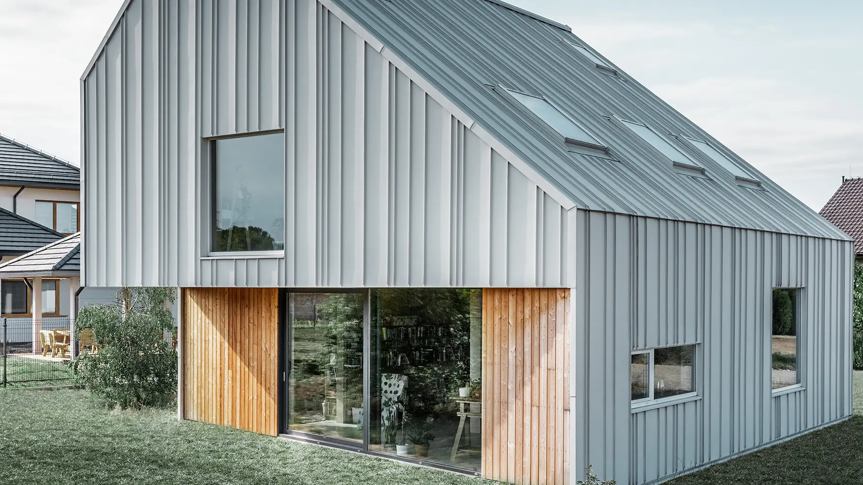 Maison individuelle moderne au toit et à la façade recouverts de bandes PREFALZ de différentes largeurs