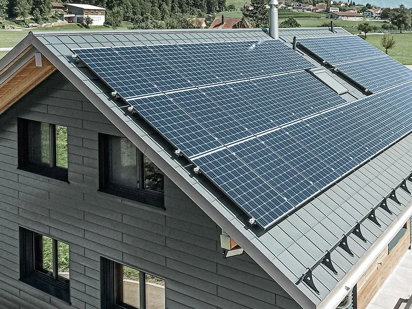 [Translate to Deutsch:] Photovoltaikanlage auf PREFA Dach montiert mit den Solarhaltern und der Profilschiene für sicheren Halt.