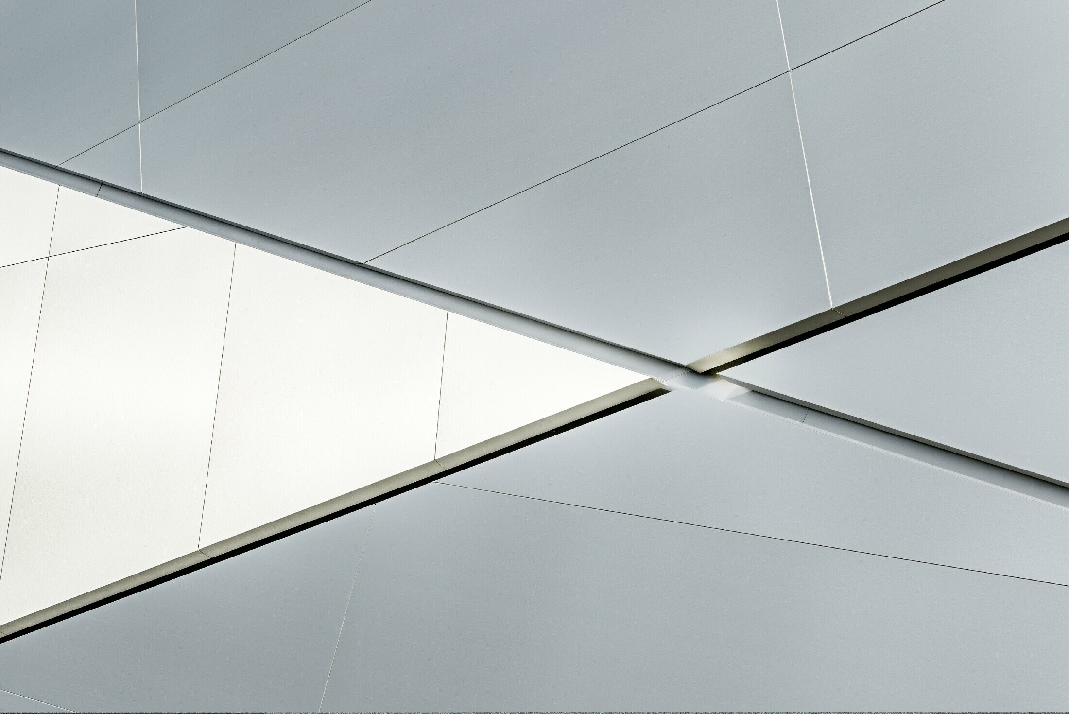 Bâtiment d’entreprise de la société Fill — Façade futuriste aux joints rétroéclairés réalisée avec des panneaux composites PREFA en aluminium brossé