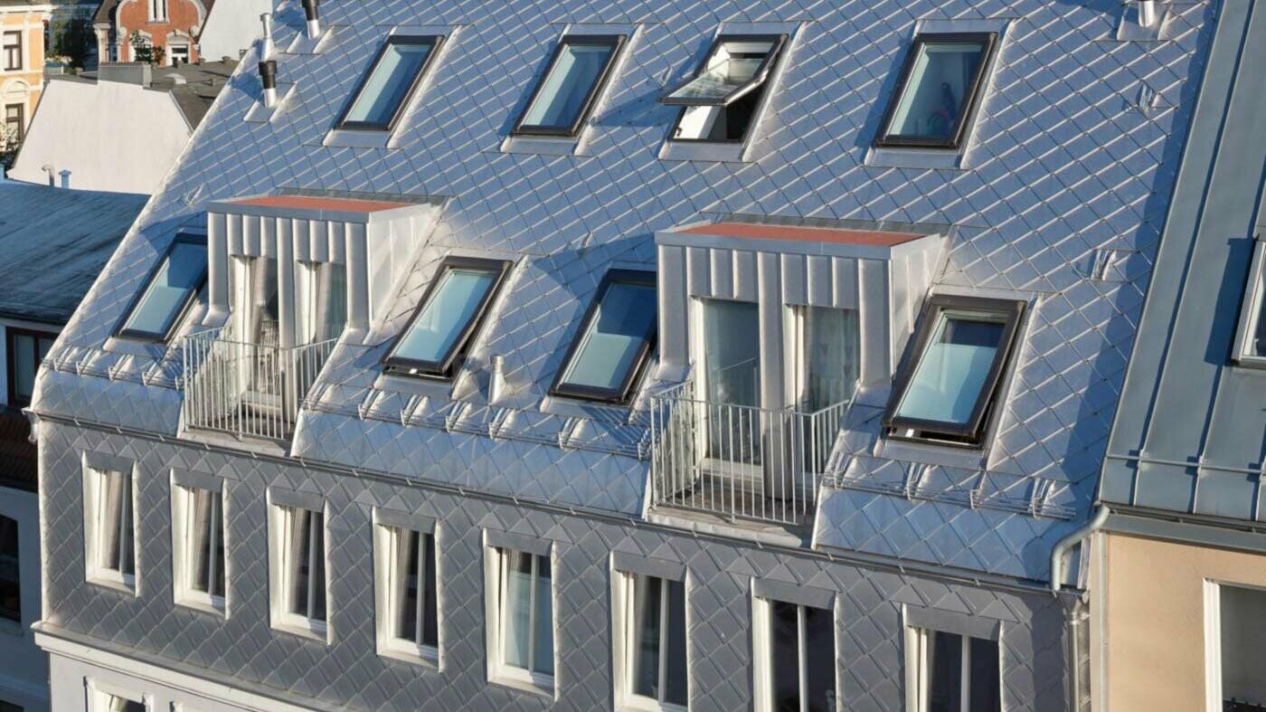 Blankes Aluminium-Schuppendach bei Dachgeschossausbau mit vielen Dachflächenfenstern