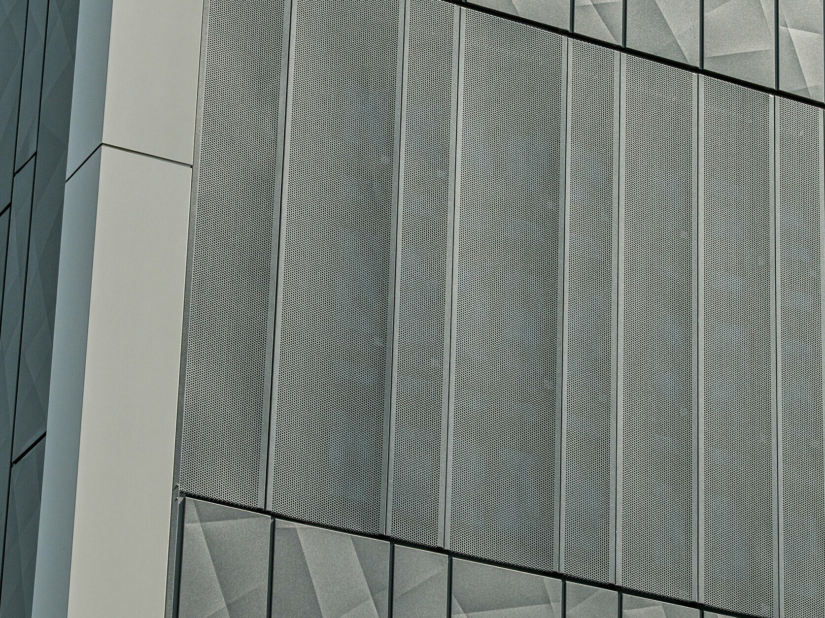 Fassadenansicht eines Eurospar-Markts in Rohrbach mit PREFA Siding.X und perforierten Sidings in der Farbe Anthrazit. Die Siding.X-Elemente zeigen ein lebendiges, geometrisches Fugenbild, während die perforierten Sidings eine moderne, luftdurchlässige Struktur bieten.