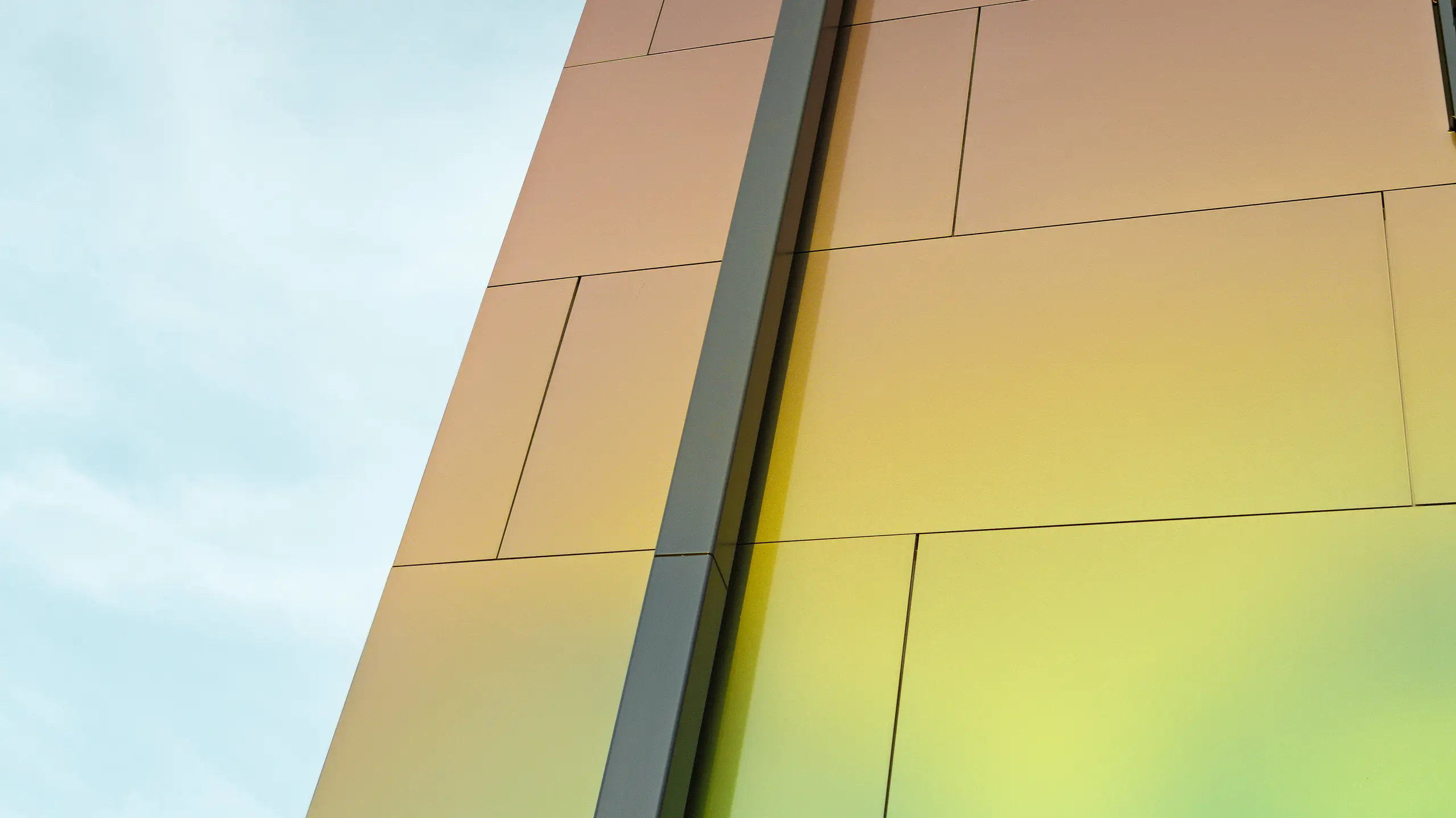 Hauskante eines modernen Einfamilienhauses mit dem modernen Ablaufrohr PREFA Quadratrohr zur Entwässerung des Flachdaches. Die Fassade ist mit der Aluminium Verbundplatte in der schillernden Farbe "spring lake" verkleidet.