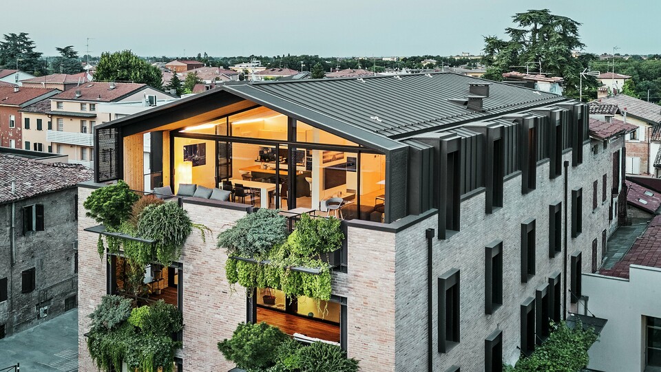 Nachhaltiges Wohnhaus in Italien mit PREFALZ Aluminiumdach und begrünter Backsteinfassade.