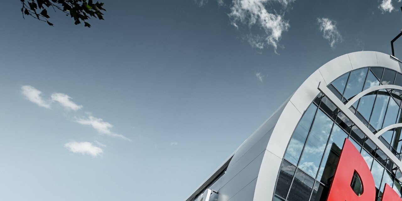 L’entrée de l’Allianz Stadion avec le grand logo du SK Rapid de Vienne ; le tube avec la grande façade vitrée est recouvert du panneau composite en aluminium PREFA couleur argent métallisé.