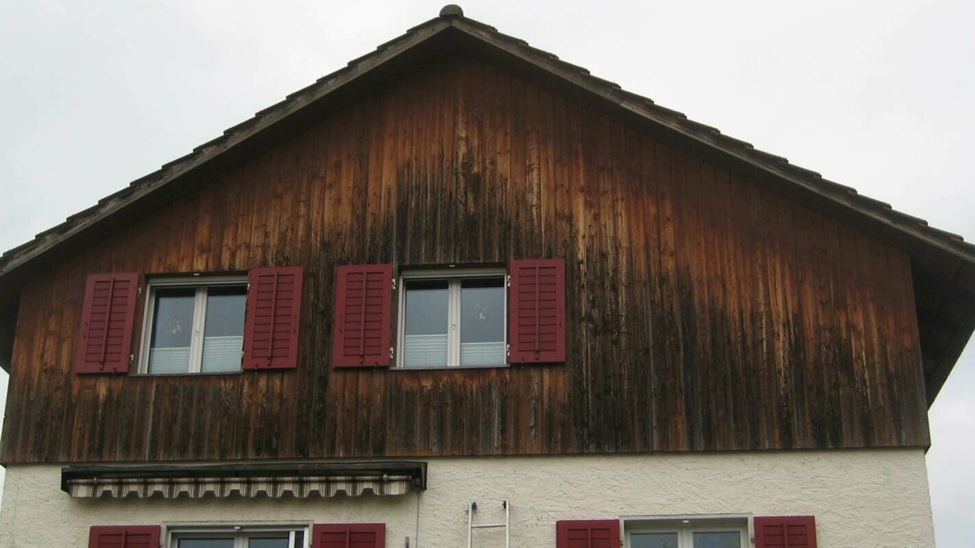 Hausfassade mit abgewittertem Holz vor der Sanierung mit PREFA Sidings