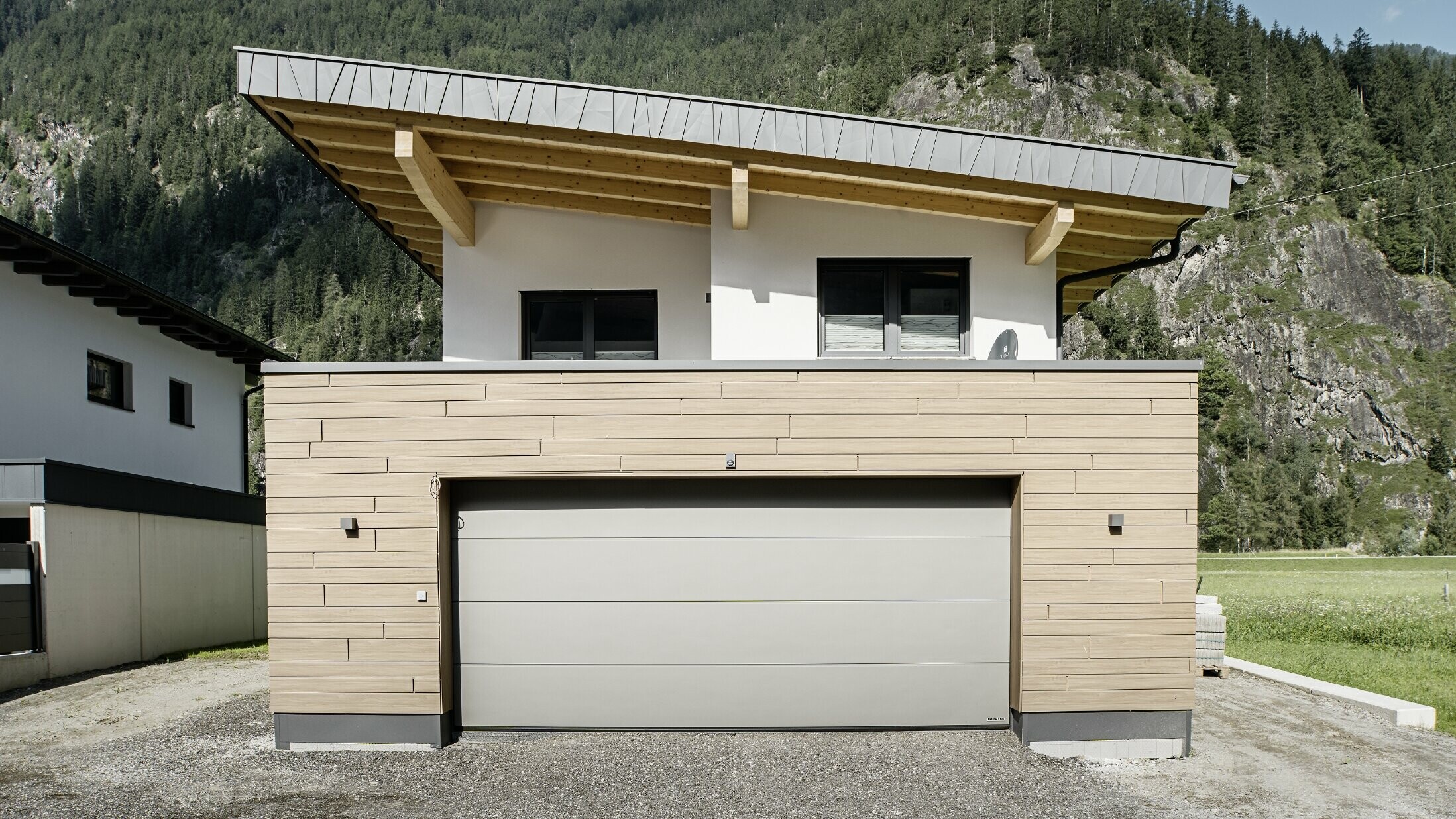 Nouvelle construction moderne avec toit en appentis et bardage individuel, garage avec toit plat et façade en aluminium noyer foncé de PREFA. Les Sidings ont été posés horizontalement et dans différentes largeurs utiles.