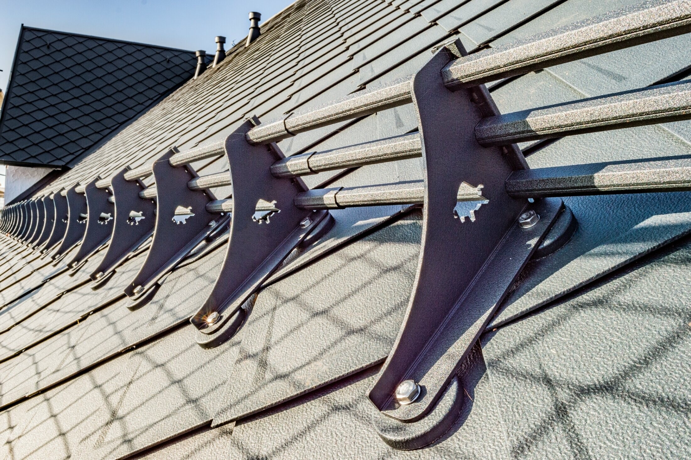 Vue détaillée du système pare-neige PREFA sur le losange de toiture 29 × 29 PREFA couleur anthracite sur l’hôtel Burg Maienluft.