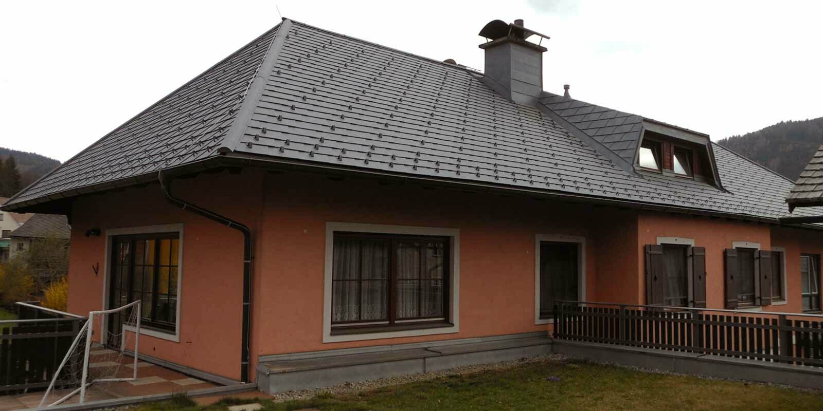 Rénovation de toiture d’une maison avec toit à croupes et lucarne en trapèze, à l’aide de bardeaux de toiture PREFA