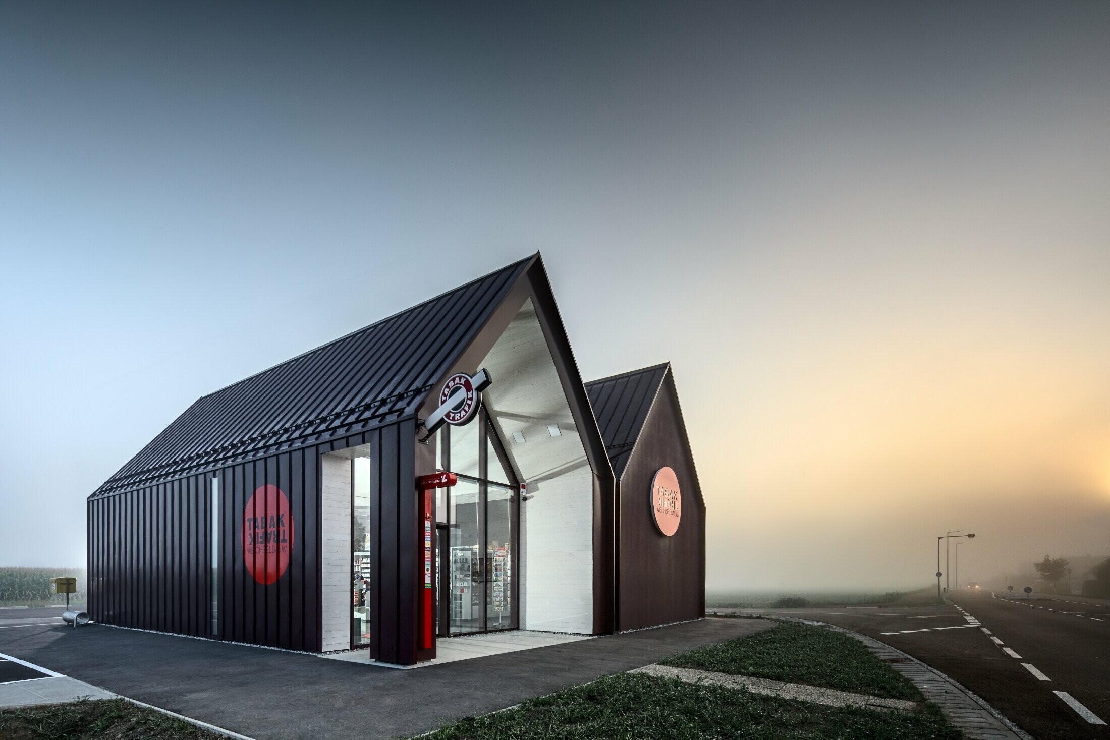 Bureau de tabac moderne au toit à deux versants sans saillie de façade — Enveloppe en aluminium PREFA à joints debout et joints angulaires rouge-noir (couleur spéciale)