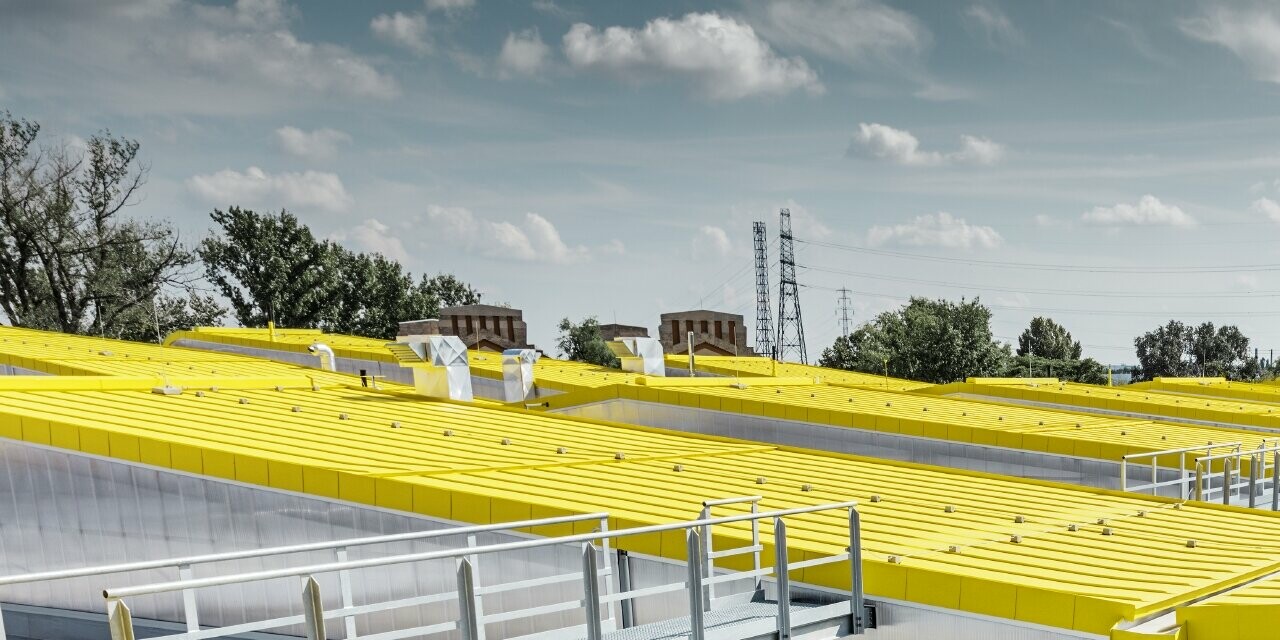 Vue détaillée de la surface de toiture jaune du nouvel entrepôt de Budapest avec toit à joint debout de PREFA ;